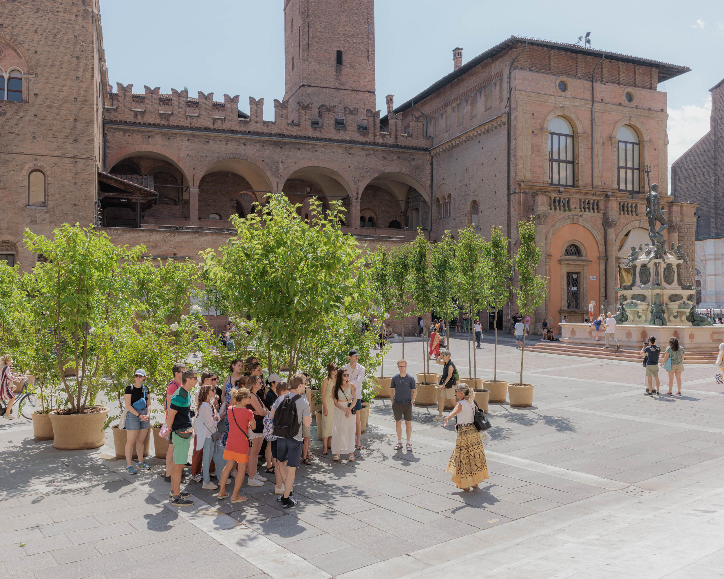 A group of tourists seeks shelter in the shade of potted trees. In the summer of 2025, the Municipality of Bologna installed around one hundred movable trees in the city’s main tourist squares as a strategy to itigate urban heat islands. According to ISPRA, Italy’s Institute for Environmental Protection and Research, approximately 20 hectares of land are sealed by concrete and asphalt every year in the same area.
This comparison reveals the inadequacy of such measures when confronted with the true scale of the climate crisis. Bologna, Jul 2025.